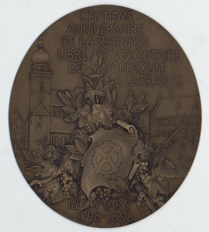 Médaille montrant la roue de Mulhouse devant la place de la Réunion 