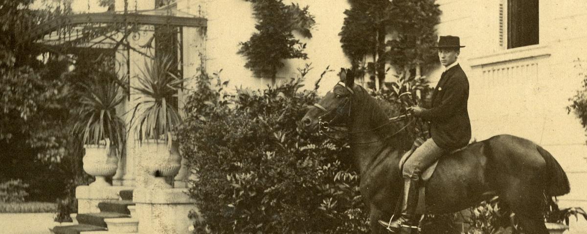 Photographie d'Alfred Wallach à cheval devant sa maison